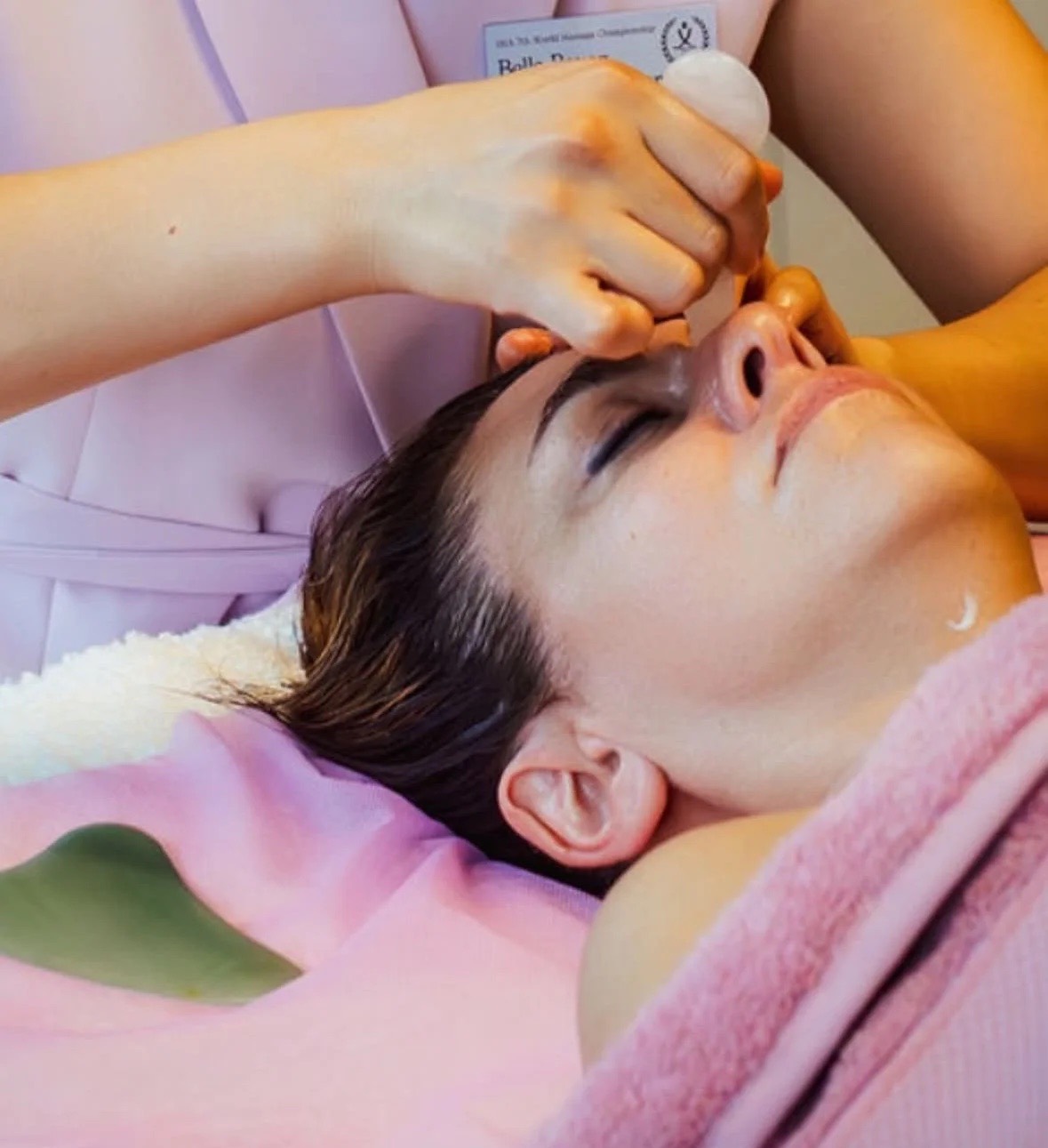 En Gua Sha-sten formar kindbenet under en behandling